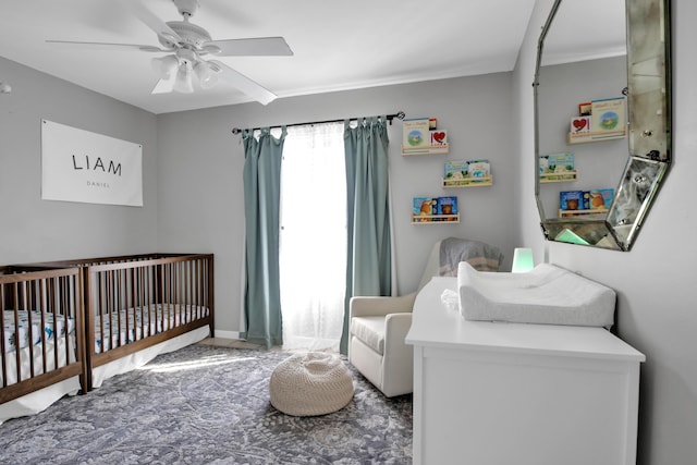 bedroom featuring ceiling fan and a crib