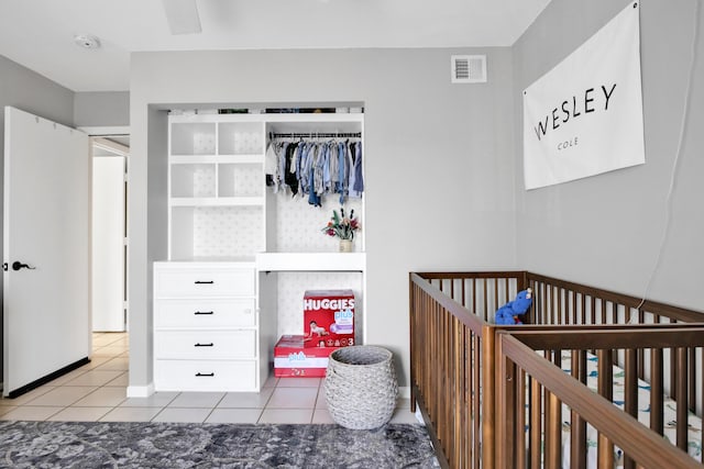 bedroom with a nursery area and light tile patterned flooring