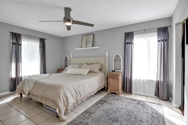 bedroom with multiple windows, light tile patterned floors, and ceiling fan