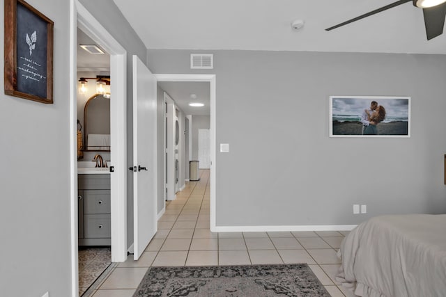 bedroom with ceiling fan, sink, ensuite bath, and light tile patterned floors