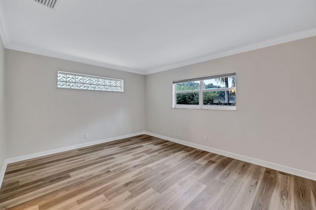 empty room with crown molding and light wood-type flooring