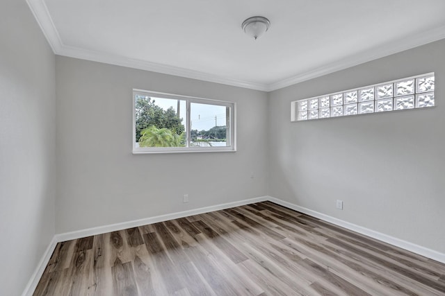 empty room with ornamental molding and wood-type flooring