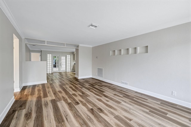 empty room with hardwood / wood-style flooring, ornamental molding, and french doors