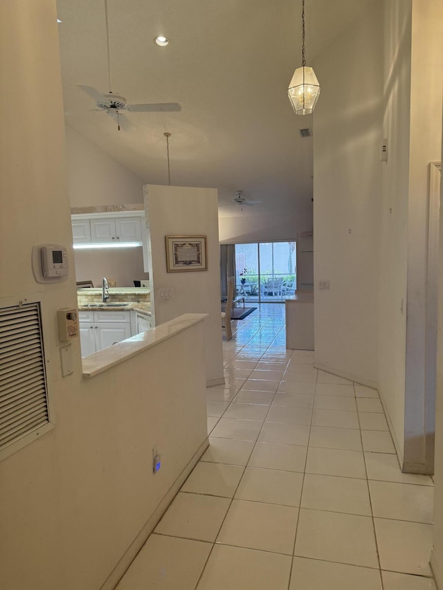 hallway featuring light tile patterned floors, high vaulted ceiling, and sink