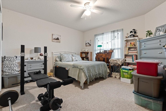 carpeted bedroom featuring ceiling fan and a textured ceiling