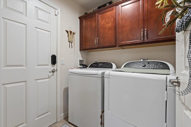 washroom featuring washer and clothes dryer and cabinets