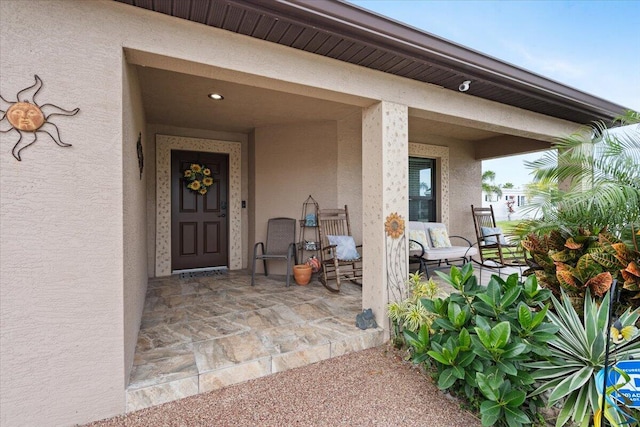 view of exterior entry with a patio area