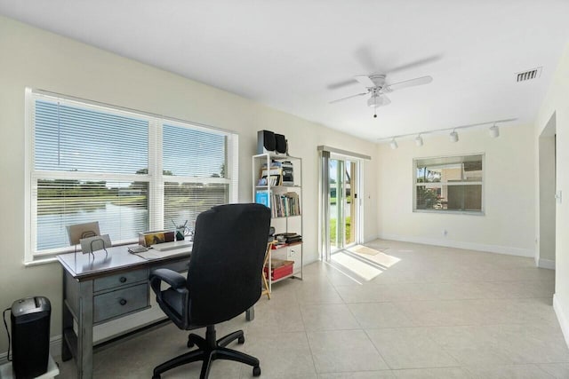 tiled office featuring ceiling fan, a healthy amount of sunlight, and rail lighting