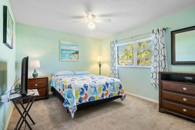 bedroom featuring light carpet, ceiling fan, and a textured ceiling