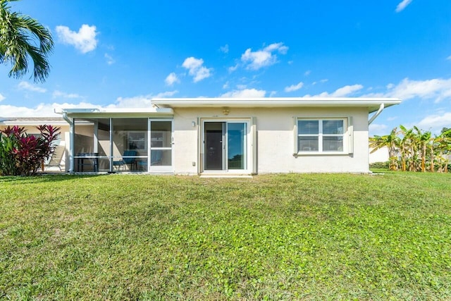 back of property featuring a sunroom and a yard