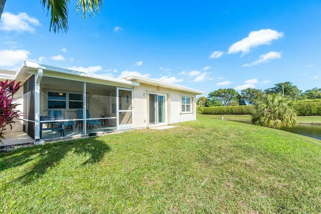 rear view of house with a sunroom and a lawn