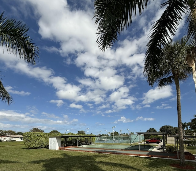 exterior space featuring tennis court and a lawn