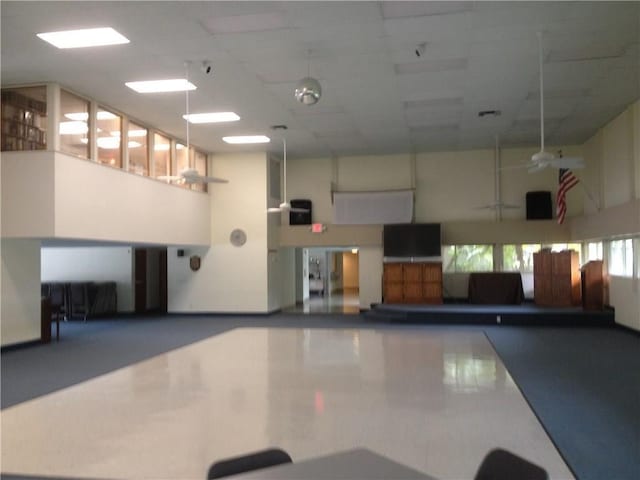 interior space with ceiling fan and a towering ceiling