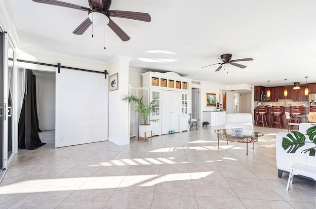 tiled living room with ornamental molding, a barn door, and ceiling fan