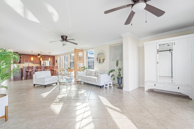 living room featuring crown molding, light tile patterned floors, and ceiling fan