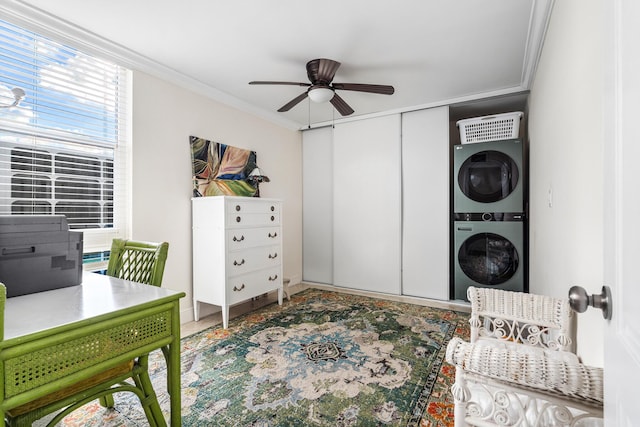 office featuring crown molding, ceiling fan, and stacked washing maching and dryer