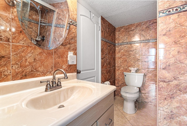 bathroom featuring tile walls, vanity, toilet, tile patterned floors, and a textured ceiling