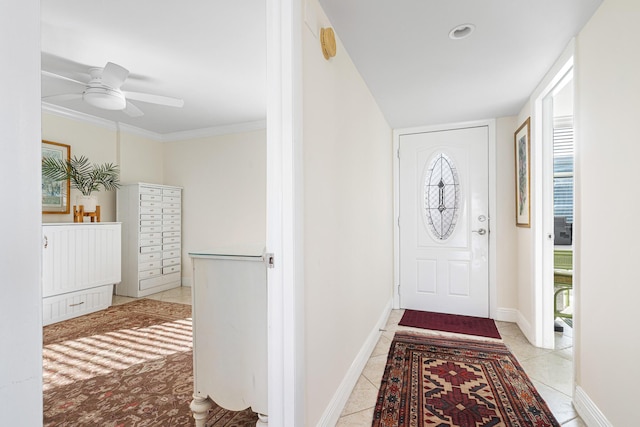 tiled entrance foyer featuring ornamental molding and ceiling fan