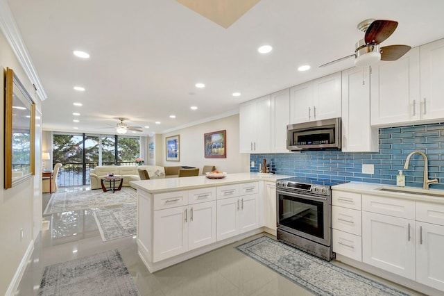 kitchen with white cabinetry, sink, kitchen peninsula, and appliances with stainless steel finishes