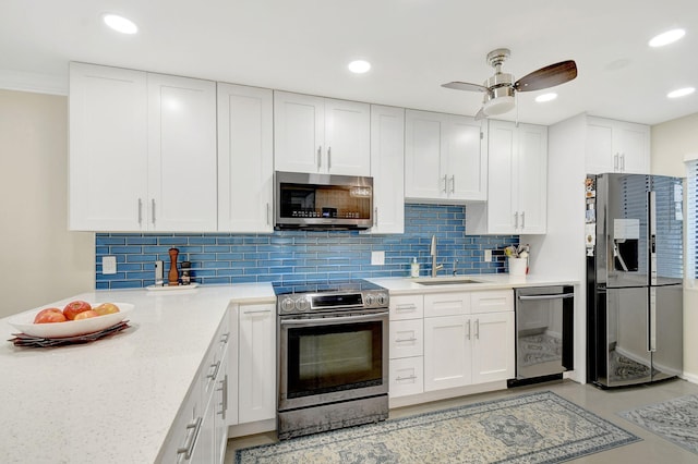 kitchen featuring stainless steel appliances, sink, white cabinets, and decorative backsplash