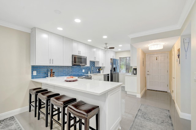 kitchen with sink, kitchen peninsula, white cabinets, and appliances with stainless steel finishes