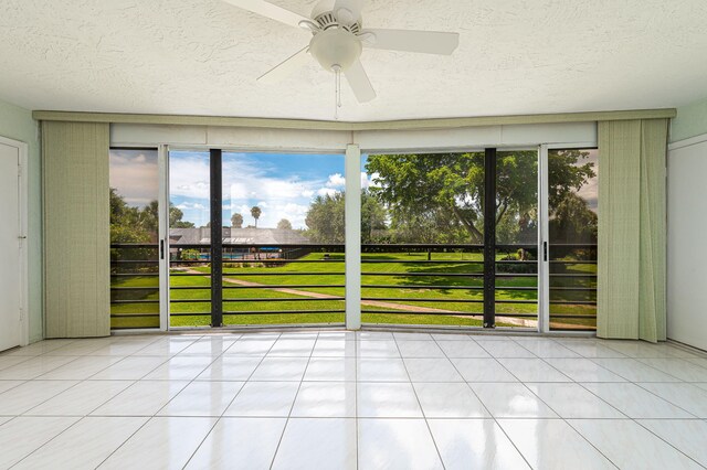 unfurnished sunroom with ceiling fan