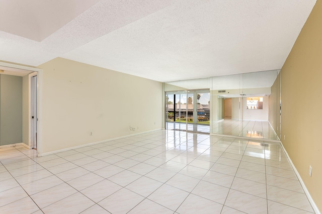 spare room featuring light tile patterned floors and a textured ceiling