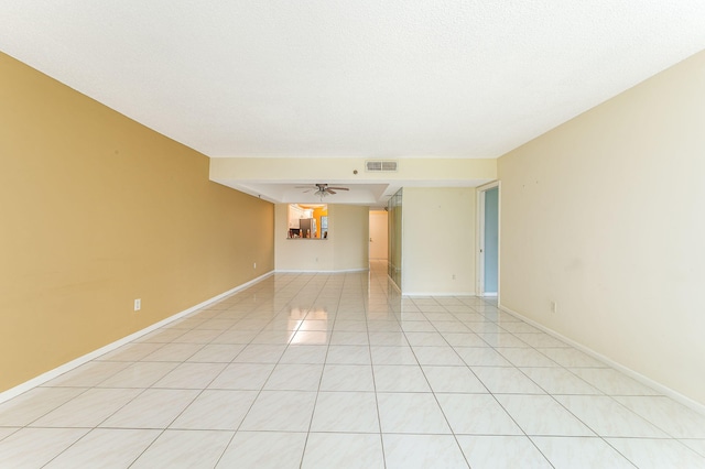 spare room featuring light tile patterned floors, a textured ceiling, and ceiling fan