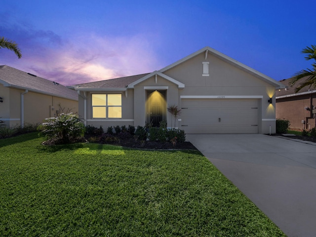 ranch-style house with a garage and a lawn