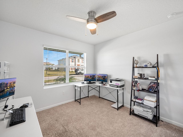 home office featuring ceiling fan, light colored carpet, and a textured ceiling