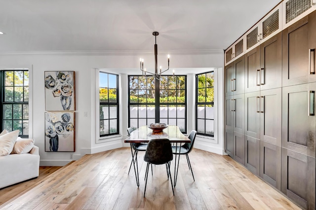 dining space with crown molding, a chandelier, and light hardwood / wood-style floors