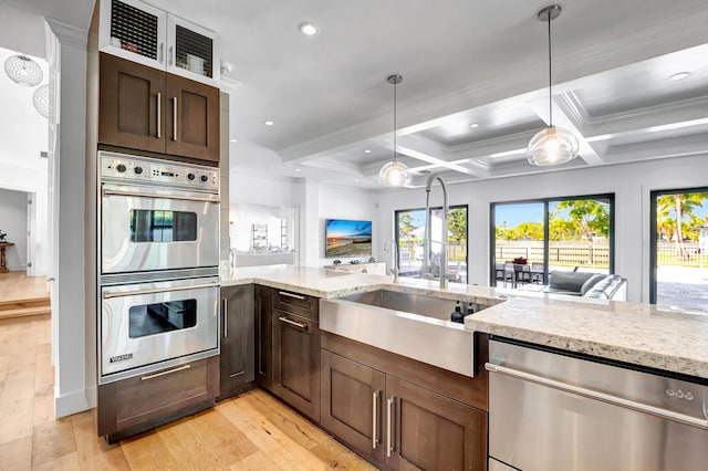 kitchen with appliances with stainless steel finishes, beam ceiling, coffered ceiling, light stone countertops, and light wood-type flooring