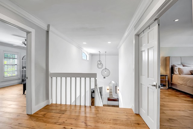 hallway with crown molding and light hardwood / wood-style flooring