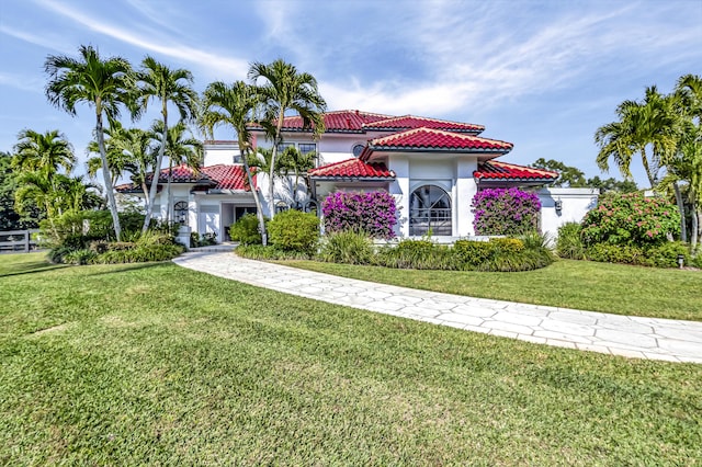 mediterranean / spanish house featuring a front yard