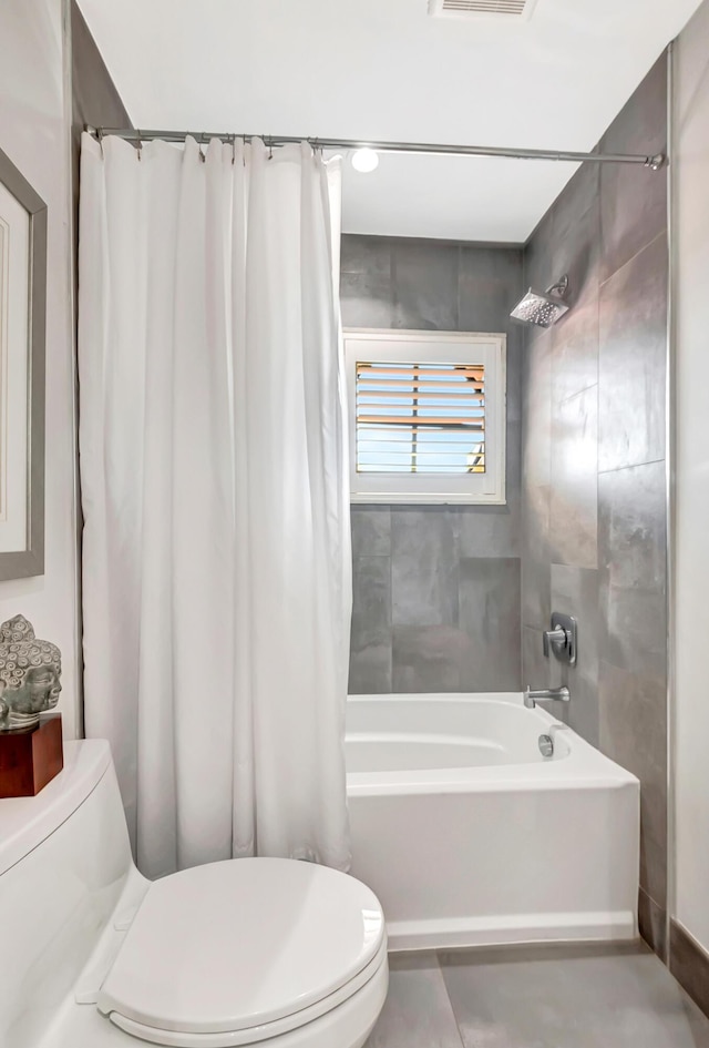 bathroom featuring shower / tub combo with curtain and toilet