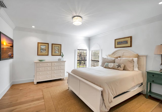 bedroom with ornamental molding and light wood-type flooring