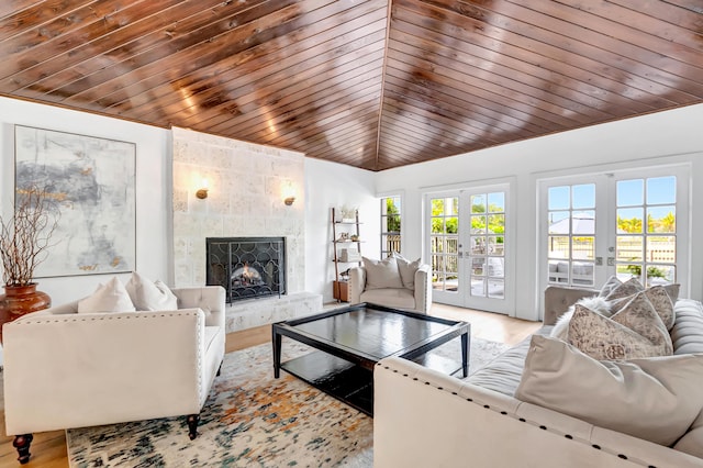 living room with a tiled fireplace, wooden ceiling, and french doors