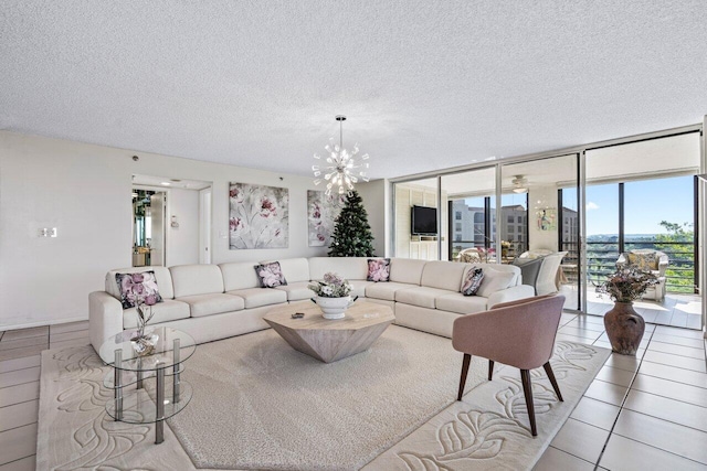 tiled living room with a notable chandelier, expansive windows, and a textured ceiling