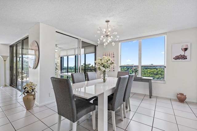 dining space with an inviting chandelier, a textured ceiling, and light tile patterned flooring