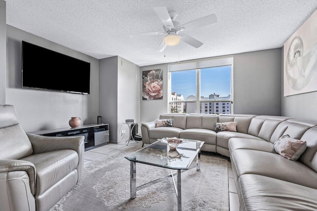 living room featuring light tile patterned floors, a textured ceiling, and ceiling fan