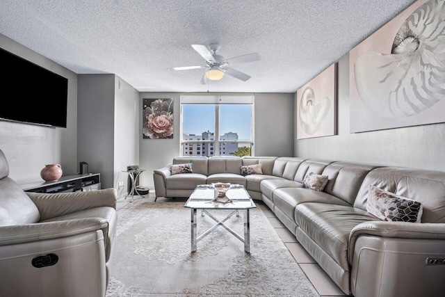 living room with light tile patterned flooring, ceiling fan, and a textured ceiling