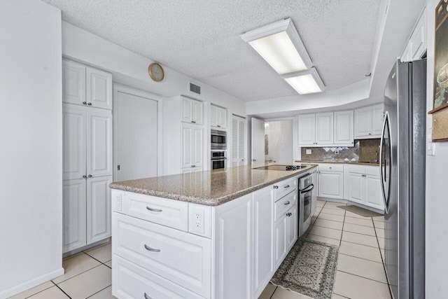 kitchen featuring white cabinetry, appliances with stainless steel finishes, a kitchen island, and light tile patterned floors