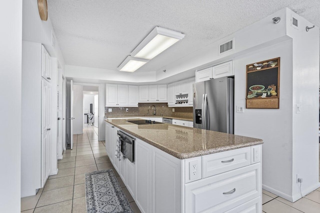 kitchen featuring white cabinetry, tasteful backsplash, stone countertops, a center island, and stainless steel fridge with ice dispenser