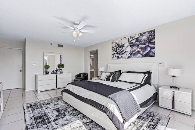 tiled bedroom featuring ensuite bath, a textured ceiling, and ceiling fan