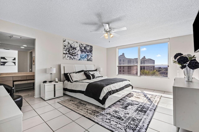 tiled bedroom featuring ceiling fan, connected bathroom, and a textured ceiling