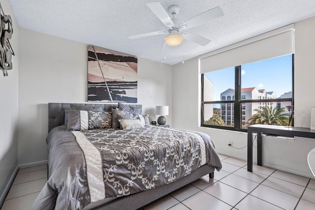 tiled bedroom featuring ceiling fan and a textured ceiling