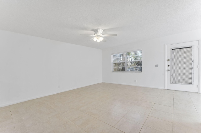 tiled spare room featuring a textured ceiling and ceiling fan