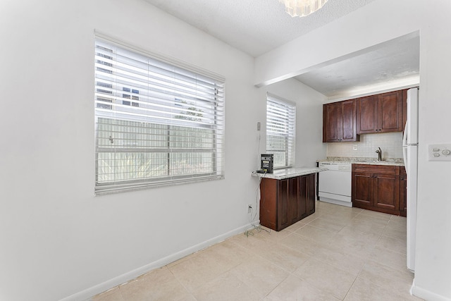 kitchen featuring sink, white appliances, backsplash, a textured ceiling, and light tile patterned flooring