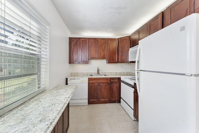 kitchen featuring light stone countertops, sink, light tile patterned floors, and white appliances