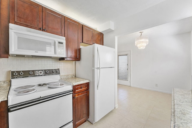 kitchen featuring an inviting chandelier, decorative light fixtures, white appliances, light stone countertops, and decorative backsplash